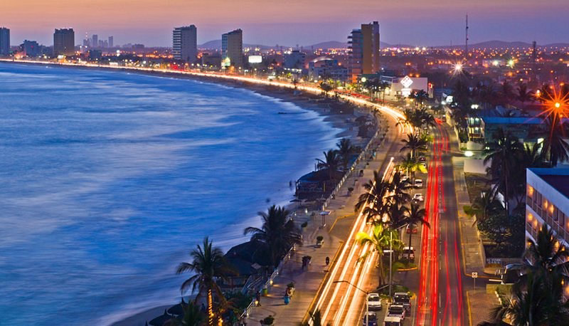 Malecón de Mazatlán frente al océano Pacífico durante el atardecer.